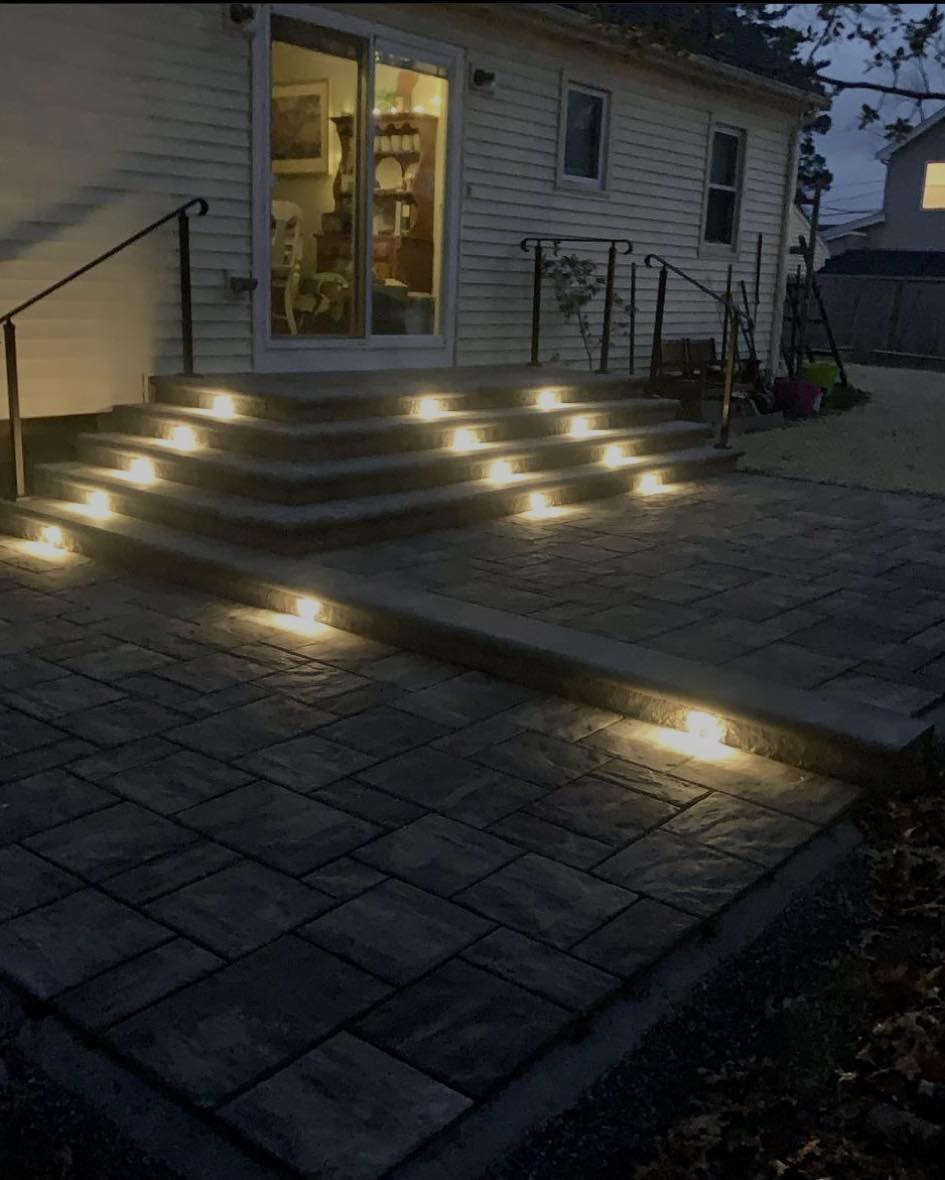 Finished bluestone steps lit at dusk by a Maginnis Landscape project
