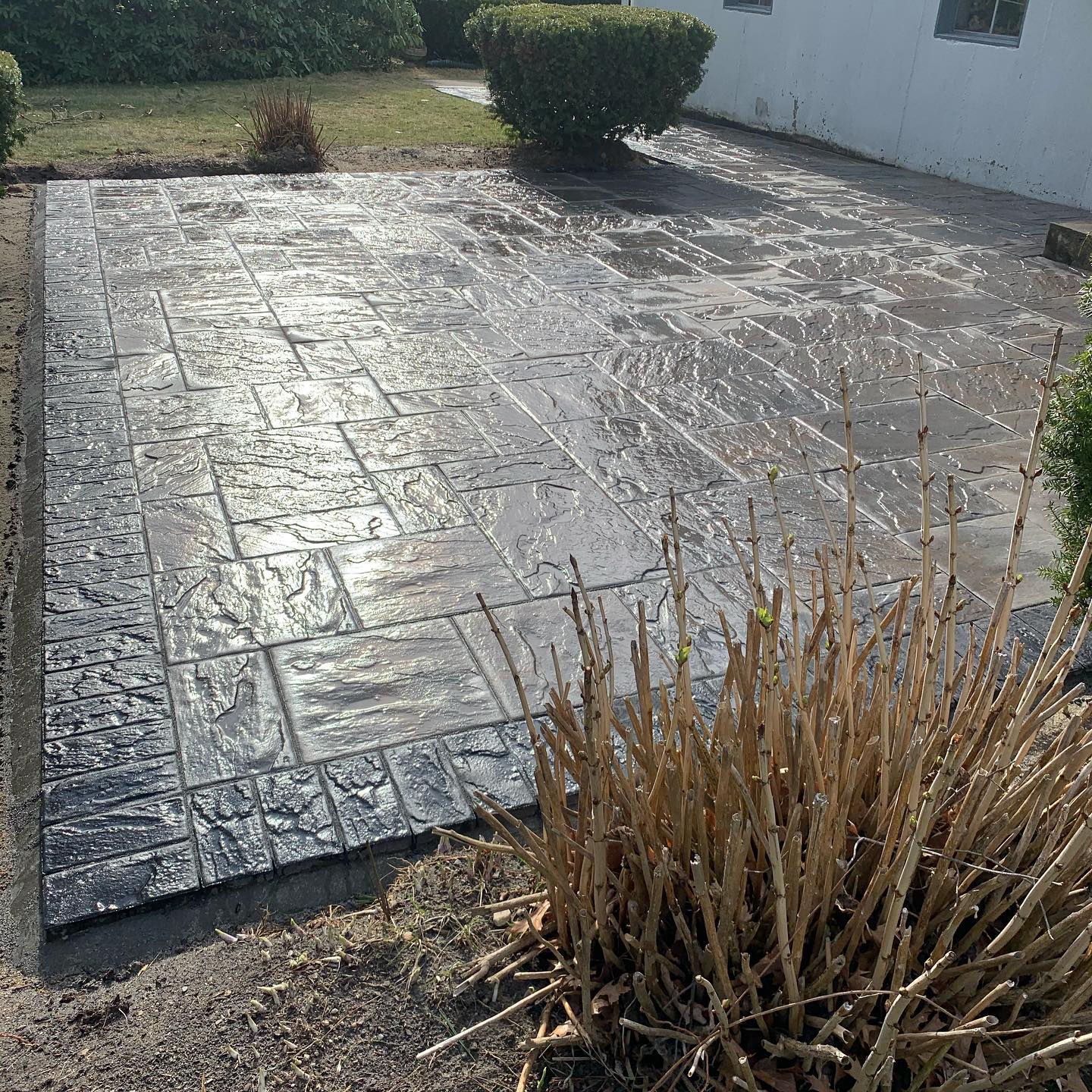 A finished paver patio with a stone fire pit